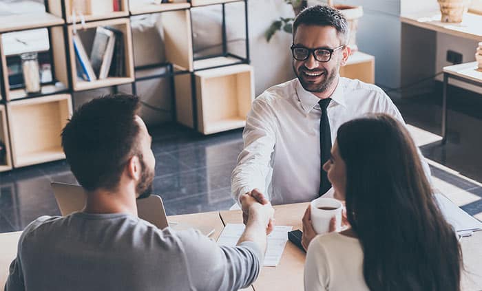 a man closing a deal with a couple